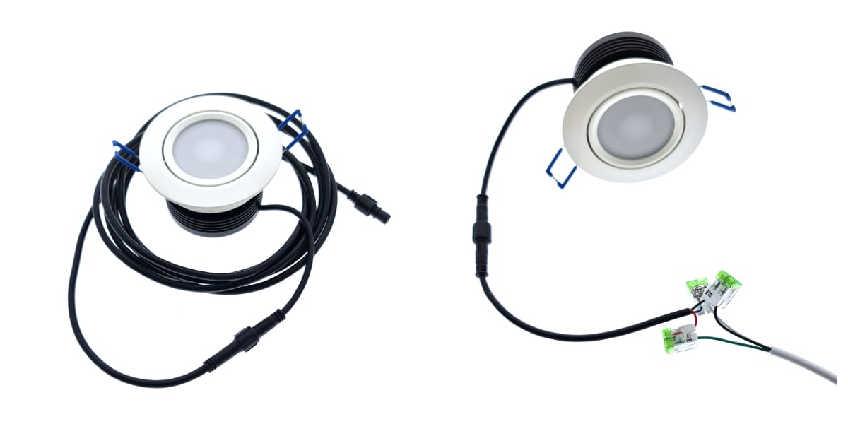 Spottikollaasi kaksi tapaa liittää - LedStore Kaksi pyöreää LED-alasvaloa, joissa on valkoiset kehykset, on kiinnitetty pitkiin mustiin johtoihin. Valoissa on liittimet johtojen päissä. Toinen johto on kierretty, kun taas toinen ulottuu ja yhdistyy vihreisiin riviliittimiin korostaen oman tyylikkään LED-integraatiota.